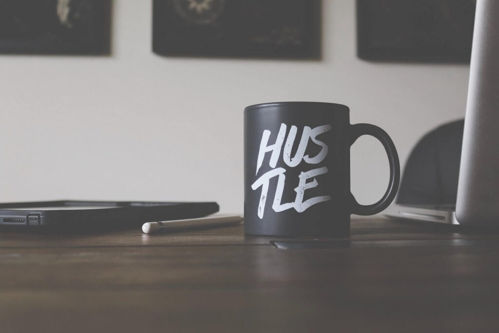 Hustle written in white on a black mug | Creating a Profitable Side Hustle